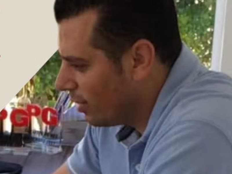 Adriano trabalhando no notebook em uma mesa de escritório