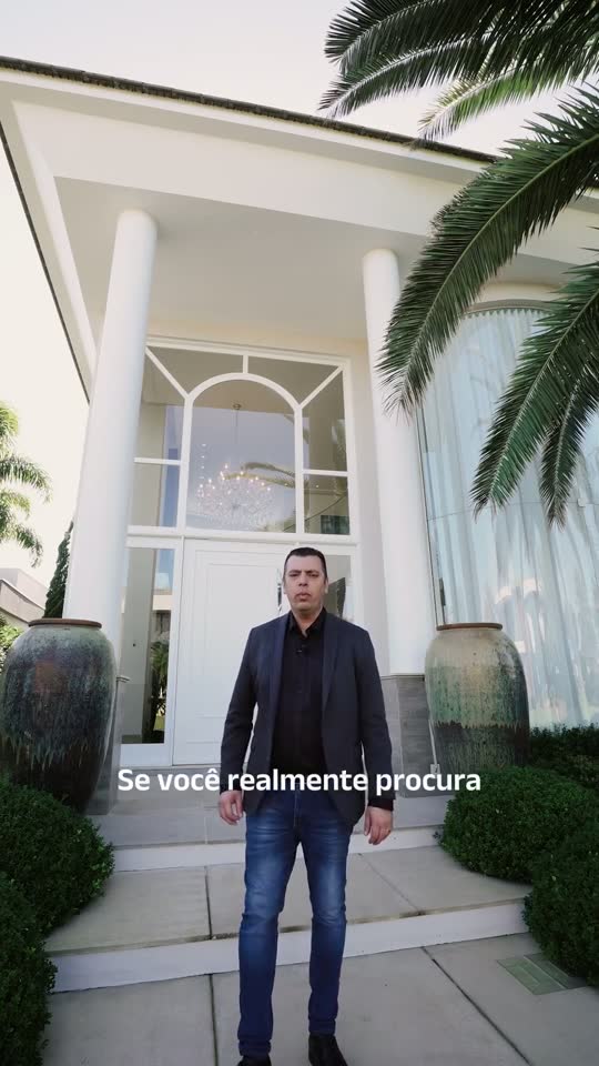 Adriano em frente a um sobrado à beira-mar